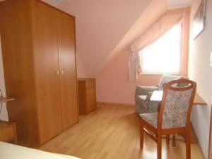 ein Schlafzimmer mit einem Bett und einem Stuhl und einem Fenster in der Unterkunft Ferienwohnung für 5 Personen in Radewege, Berlin in Radewege + 7 Fotos