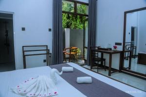 ein Schlafzimmer mit einem Bett und einem Tisch und Stühlen in der Unterkunft Zeyora Mirissa in Mirissa