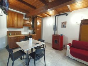 a kitchen with a table and chairs and a couch at Le coste sul lago in Montefiascone
