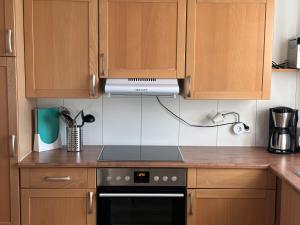 a kitchen with wooden cabinets and a stove top oven at Haus Betty in Rattelsdorf