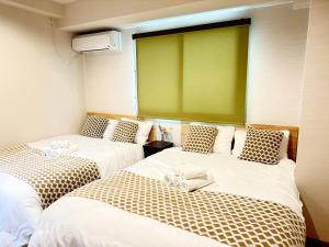 two beds in a room with a green screen at OmOTeNaShI YAHIRO in Tokyo