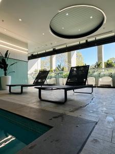 zwei Laptops auf einem Tisch in einem Raum mit einem Pool in der Unterkunft Sunny Room in Parramatta in Sydney