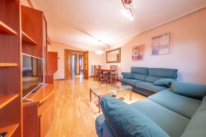 a living room with a blue couch and a tv at Historic Village Escape in Burgo de Osma in El Burgo de Osma +53 photos