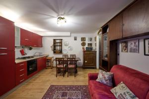 a living room with a red couch and a kitchen at Bilocale Fiocco Di Neve in Limone Piemonte