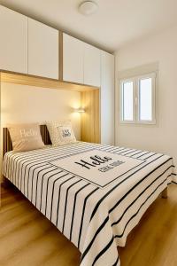 a bedroom with a large bed with a striped blanket at SANTA BEACH in Roses