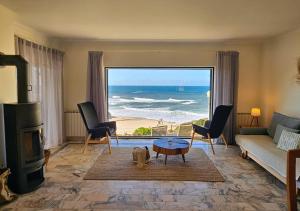 een woonkamer met uitzicht op de oceaan bij Panorama SeaView House in Marinha Grande
