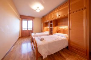 two beds in a room with wooden cabinets at Historic Village Escape in Burgo de Osma in El Burgo de Osma