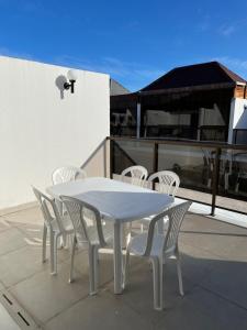 a white table and white chairs on a patio at Casa em condomínio na praia in Cabedelo +4 photos