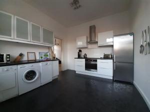 a kitchen with white cabinets and a washer and dryer at City Fewo Stricker in Bad Sachsa