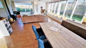 a restaurant with a table and chairs and a couch at Hello Zeeland - Oosterpark 14 in Oostkapelle