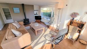 a living room with a couch and chairs and a table at Hello Zeeland - Oosterpark 14 in Oostkapelle +16 photos