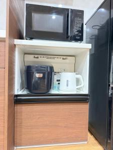 a microwave oven sitting on top of a refrigerator at OmOTeNaShI YAHIRO in Tokyo