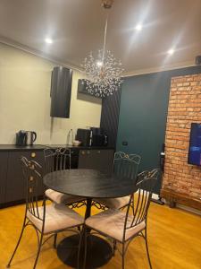 einen Esstisch mit Stühlen und einem Kronleuchter in der Unterkunft SSN Apartment in Turda