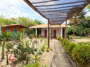 une maison avec une pergola en bois dans un jardin dans l'établissement Portoalegre del hamaquero, à Puerto Escondido