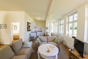 a living room with a couch and a table at Wohnung Im Ersten Obergeschoss Des Gutshauses in Neuenkirchen