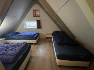 a room with two beds in a attic at Bungalowpark Simpelveld - Alpha 97 in Simpelveld