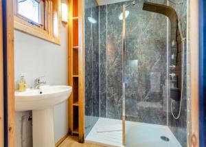une salle de bain avec douche et lavabo dans l'établissement Castlewood Lodges, à Strachan