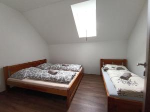 two twin beds in a room with a window at Apartmánový Dom Terchová in Terchová