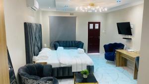 a hotel room with a bed and blue chairs at Crown Palace Guesthouse in Pretoria +45 photos