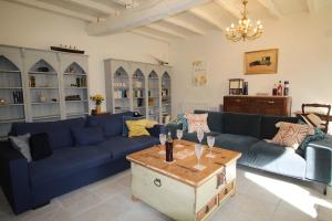 a living room with blue couches and a coffee table at Charente Cozy Family Winter Retreat in Theil-Rabier
