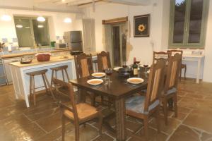 a kitchen with a wooden table and chairs in a kitchen at Charente Cozy Family Winter Retreat in Theil-Rabier