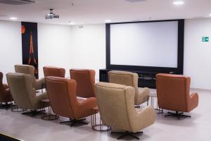 a conference room with a table and chairs and a large screen at Equilíbrio PARK VEREDAS - Rio Quente-Goias in Rio Quente +61 photos