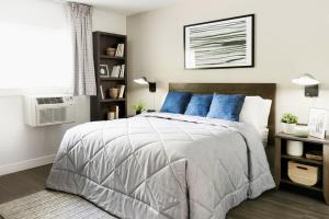a bedroom with a large bed with blue pillows at InTown Suites Extended Stay Atlanta GA - Forest Park in Forest Park