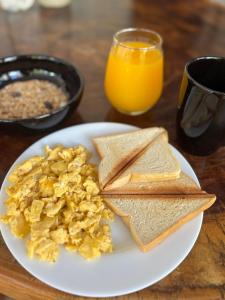 a plate of eggs and toast and a glass of orange juice at Las Tekas in Santa Marta