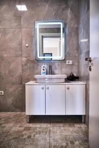 a bathroom with a white sink and a mirror at Kalpazo Tirana Mosaic in Tirana