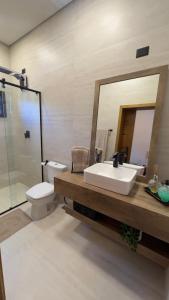 un bagno con lavandino, WC e specchio di Canto da Nega - Seu canto na Praia! a Itapoa Altre 23 foto