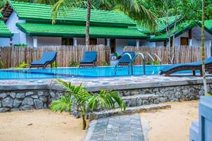 Una piscina con sillas azules al lado de una casa. en Omeesha Beach Hotel, en Kalpitiya
