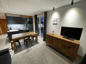 a kitchen and living room with a table and a television at Appartement 2 pièces, 4 pers, balcon, parking, sauna - FR-1-263-87 in Valloire