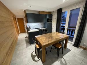 a kitchen with a wooden table and chairs at Appartement 2 pièces, 4 pers, balcon, parking, sauna - FR-1-263-87 in Valloire