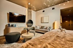 a bedroom with a large bed and a living room at Balder Luxury Lodge & Glass Igloos in Levi