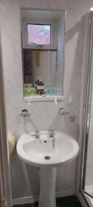 ein weißes Badezimmer mit Waschbecken und Spiegel in der Unterkunft The Dreamcatcher Hotel in Blackpool