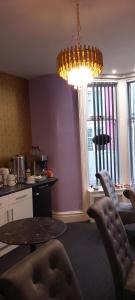ein Wohnzimmer mit einem Tisch und einem Kronleuchter in der Unterkunft The Dreamcatcher Hotel in Blackpool