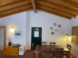 une salle à manger avec une table et une porte verte dans l'établissement CASA DAS CAMARINHAS by Stay in Alentejo, à Odemira