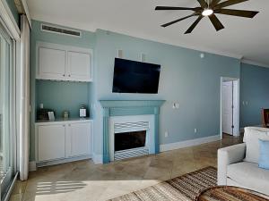 a living room with a tv above a fireplace at Adagio #203A in Santa Rosa Beach