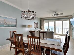 a dining room with a table and chairs and a couch at Adagio #203A in Santa Rosa Beach
