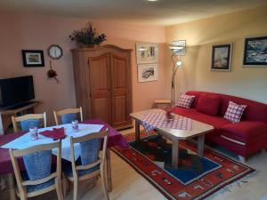 un salon avec un canapé rouge et une table dans l'établissement Ferienwohnung Seitz 2 In Bayerisch Eisenstein, à Bayerisch Eisenstein 32 autres photos