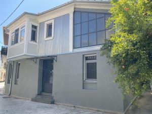a white house with glass windows on a street at eliamaria domus artificis in Lefkada Town