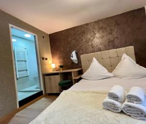 a bedroom with a bed with towels on it at Pensiunea Carina in Bran