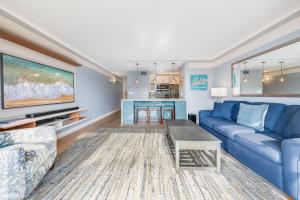 un salon avec un canapé bleu et une table dans l'établissement Sugar Beach Resort 505 condo, à Kihei