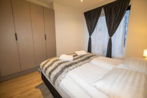 a bedroom with a large white bed with a window at New Downtown Retreat in Akureyri