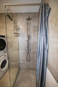 a shower with a shower curtain in a bathroom at New Downtown Retreat in Akureyri +43 photos