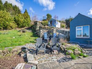 a yard with two chairs and a house at Hyfrydle Cottage in Pen-y-groes