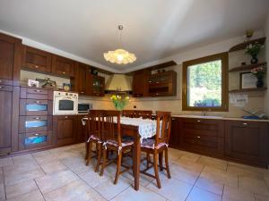 a kitchen with a table and chairs and a kitchen with wooden cabinets at Maryhouse in Borso del Grappa