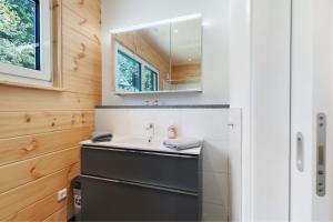 une salle de bain avec un lavabo et un miroir dans l'établissement Mettmapark - Chalet 2, à Grafenhausen 17 autres photos