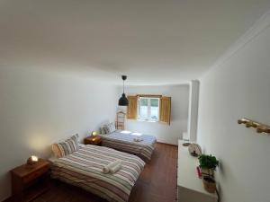 une chambre avec deux lits et une fenêtre dans l'établissement CASA DAS CAMARINHAS by Stay in Alentejo, à Odemira 54 autres photos