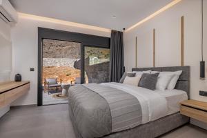 ein Schlafzimmer mit einem großen Bett und einer Glasschiebetür in der Unterkunft Amani Villa Lindos Two in Lindos + 24 Fotos